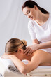 © LIGHTFIELD STUDIOS - blurred masseur massaging neck of client lying on massage table