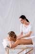© LIGHTFIELD STUDIOS - masseur massaging pleased woman on massage table in spa salon