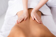 © LIGHTFIELD STUDIOS - partial view of masseur massaging back of client lying on massage table