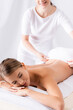 © LIGHTFIELD STUDIOS - masseur adjusting towel on beautiful client lying on massage table