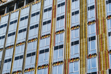 Wall Mural - Residential high-rise building under construction. Unfinished house on a construction site with cranes.