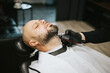 © klavdiyav - beard modeling in Barber shop, beard care for men, male beauty concept