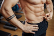© Screaghin - Muscular athletic young man bodybuilder fitness model measuring fat percent in gym. Perfect abs.