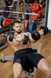 © Screaghin - Muscular athletic young man bodybuilder fitness model exercise chest with dumbbell on the bench in gym. Top view.
