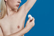 Young caucasian man using crystalized antiperspirant on underarm