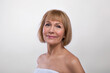 © Prostock-studio - Aging gracefully. Beauty portrait of senior lady wearing towel, having silky skin, looking at camera on light background