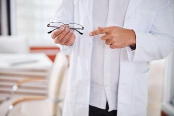 Optometrist in a lab coat showing prescription eyewear