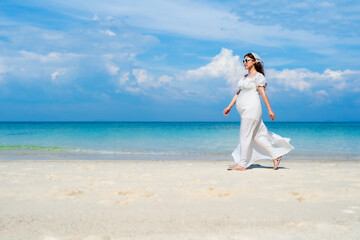 Wall Mural - pregnant woman walking on the sea beach at Koh MunNork Island, Rayong, Thailand