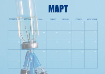 Wall Mural - A clean desktop calendar for March, for the doctor. The layout used as the schedule planner. A bottle of medicine and needles of syringes in the background. All inscriptions are in Russian