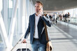 © Kaspars Grinvalds - Young man walking through airport gate and talking on phone