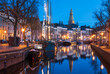 Old ships in a canal and the bell-tower of the Aa-kerk in the historic city centre of Groningen.