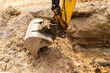 close up view of an excavator claw scoop digging a trench