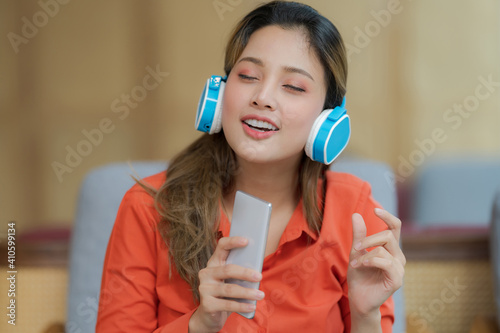 Portrait of young beautiful woman enjoying the music with smiling face © Naypong Studio