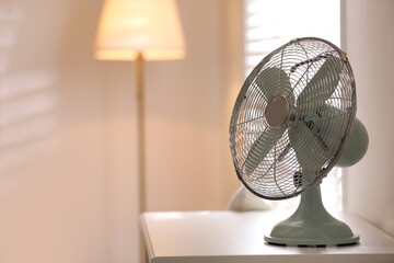 Poster - Modern electric fan on white table indoors. Space for text