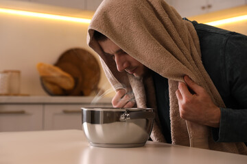 Man taking treatments at table indoors. Steam inhalation