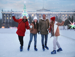 Wall Mural - Group of friends skating at outdoor ice rink