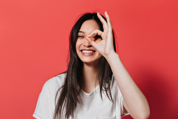 Wall Mural - Happy girl with long hair smiles and shows sign ok