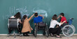 © Bangkok Click Studio - Group of special students in classroom, a down syndrome girl, two handicapped boys and  two female teachers drawing and painting on black board together
