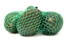Close-up Of Some Organic Hass Avocado Fruits In A Green Mesh Bag Isolated On A Neutral Background.