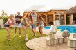 © Impact Photography - Man throwing a ball knocking down pyramid of tin cans while at a party