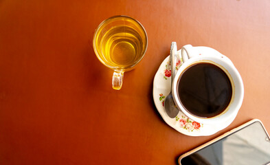 Hot coffee and tea in cup on table.