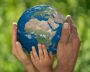 Family holding blue planet in hands. Earth day spring holiday concept. Elements of this image furnished by NASA