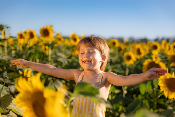 Canvas Print - Happy child playing outdoor in spring field