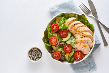 Wall Mural - Keto salad with chicken meat sous vide, tomatoes, cucumbers, avocado on pastel linen tablecloth. Mediterranean food, low calories dieting ketogenic meal, top view, copy space