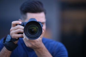 Sticker - Photographer taking picture with professional camera outdoors in evening, focus on lens