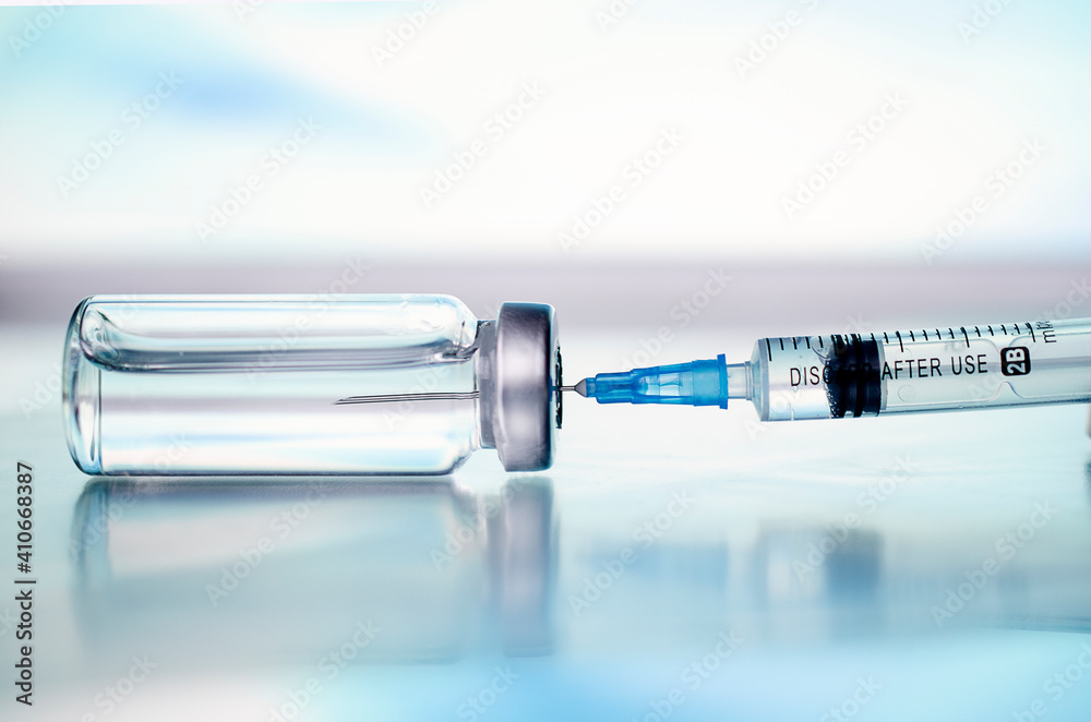 Ampoules and syringe with Covid-19 vaccine on a laboratory table.For the prevention, immunization and treatment of coronavirus infection.Infectious medicine concept. With copy space - obrazy, fototapety, plakaty 