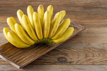 Ripe bananas on woodn background. Tasty healthy tropical fruits.