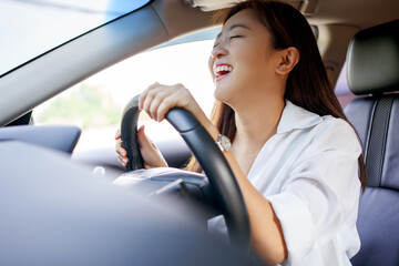 Asian woman driving on vacation. She was smiling and happy.