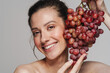 © Drobot Dean - Smiling half-naked woman posing with bunch of grapes