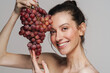 © Drobot Dean - Smiling half-naked woman posing with bunch of grapes