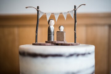 Bride and groom wedding cake topper with little bunting and showing the bride without dress as per the saying you would look beautiful in a cardboard box for a  unique married couple