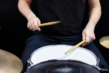 Professional drum set closeup. Man drummer with drumsticks playing drums and cymbals, on the live music rock concert or in recording studio   