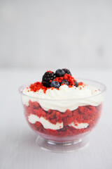 Wall Mural - homemade portioned dessert red velvet decorated with berries on a light wooden background