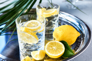 Wall Mural - Two drink glasses with lemonade on steel tray. Lemon detox drink, summer alcolic free cocktail. Healthy concept