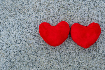 Poster - Valentine's day, two red hearts lie on a granite surface