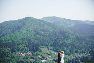 Wall Mural - happy stylish bride and groom running and having fun in mountains on summer sunny day. gorgeous newlywed couple laughing, true feelings. emotional romantic moment.