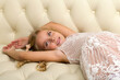 © lotosfoto - Adorable happy girl relaxing on sofa