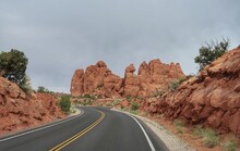 Landscape Of Road Between Orange Sandstone Rock Formations In Utah