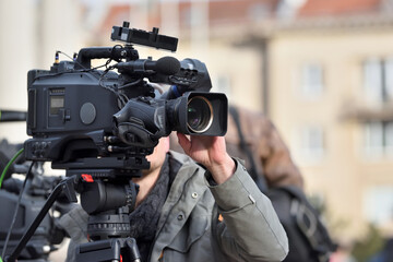 TV camera man filming a political event