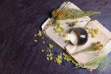 Crystal Ball Of Fortune Teller, Herbs And Old Book On Dark Background