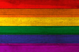 Fototapeta Tęcza - Rainbow flag painted on a wooden plank background.