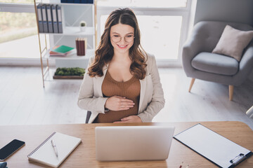 Photo portrait of pregnant woman reading looking at laptop on desk in modern office