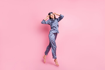 Wall Mural - full length body size photo of brunette in blue pajama jumping smiling touching sleeping mask isolat