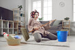© Studio Romantic - Cheerful young woman having fun and revealing hidden talent while cleaning house. Crazy housewife in hair curlers and face mask tidying up home, singing funny songs and playing on pretend mop guitar