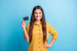 © deagreez - Photo portrait of business woman smiling keeping bank card with salary savings isolated on bright blue color background