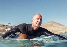 Mature Man Surfing In The Sea